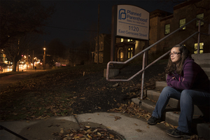 Morgan Dudzinski, a senior at Syracuse University, sits outside Planned Parenthood. She plans to go to an appointment at Planned Parenthood to discuss the possibility of receiving an intrauterine device to prevent pregnancy long-term. 
